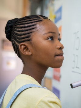 Portrait of girl writing on white board