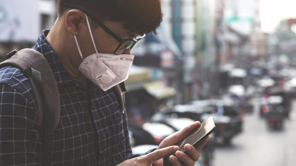 Person on their cellphone wearing a mask