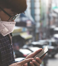 Person on their cellphone wearing a mask