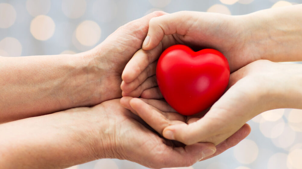 Hands holding a red cartoon heart