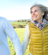 Two people holding hands in a field