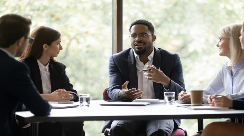 Business leader talks to other professionals at a table