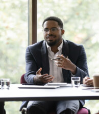 Business leader talks to other professionals at a table