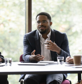 Business leader talks to other professionals at a table