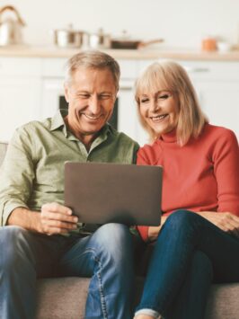 Couple sitting on couch looking at computer
